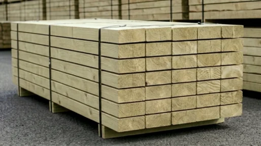 A pack of 50no. 95x195 or 100x200 Green Treated Softwood sleepers sat in a timber yard with other packs in the background