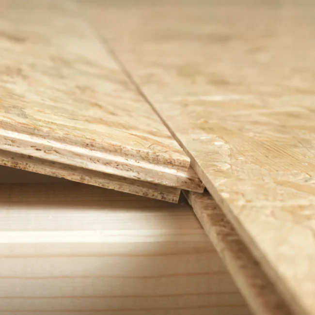 2 pieces of T&G OSB being slotted together to form a floor on top of a timber joist